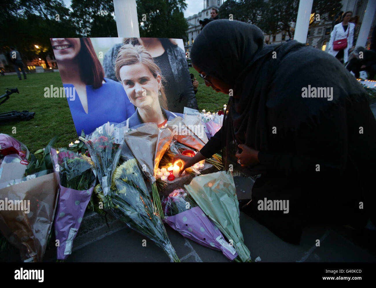 People place tributes at Parliament Square opposite the Palace of Westminster, central London, in respect to Labour MP Jo Cox, who died after being shot and stabbed in the street outside her constituency advice surgery in Birstall, West Yorkshire. Stock Photo