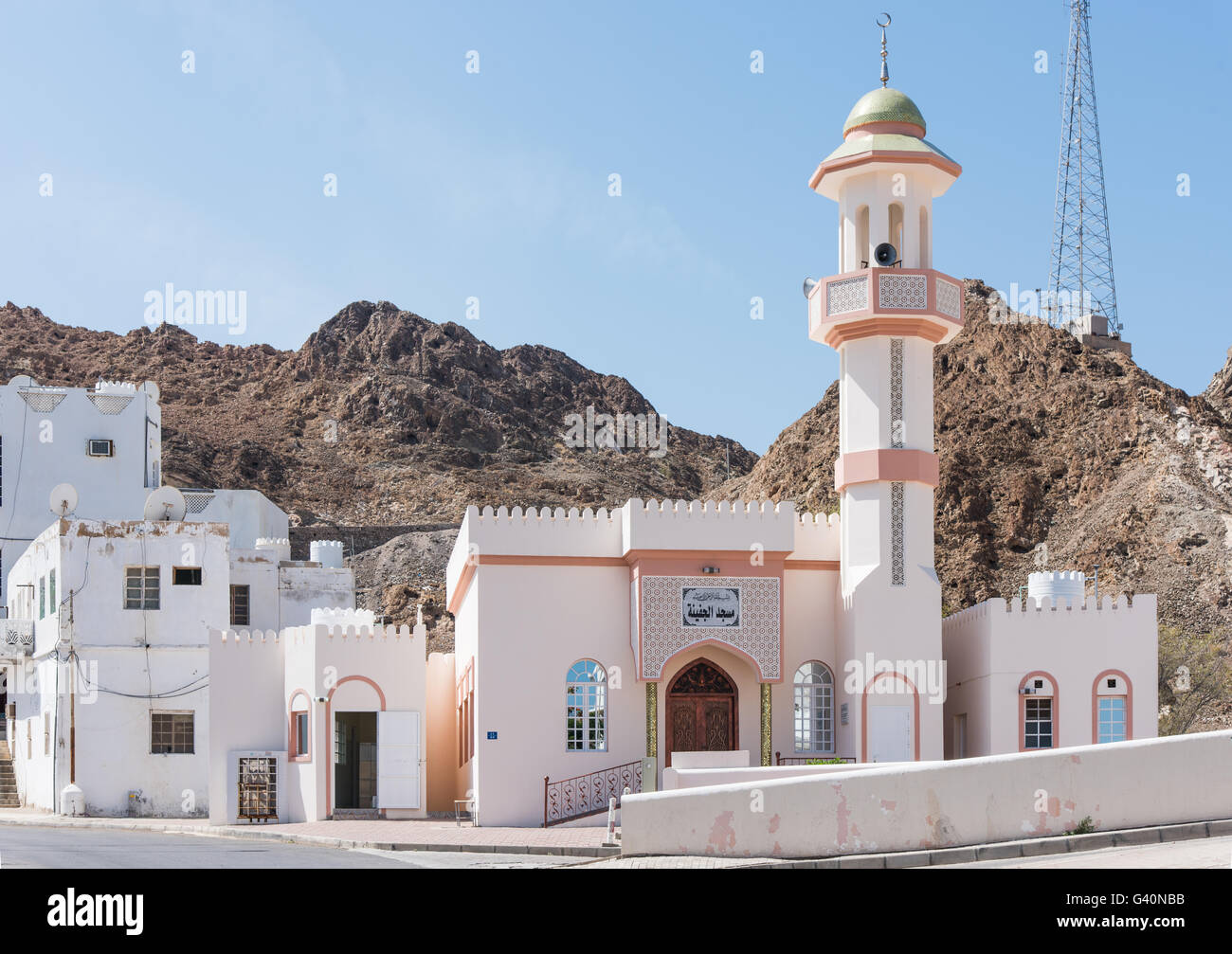 Small mosque in a typical Muscat neighbourhood with a rocky hill in the background in Muscat, Oman. Stock Photo