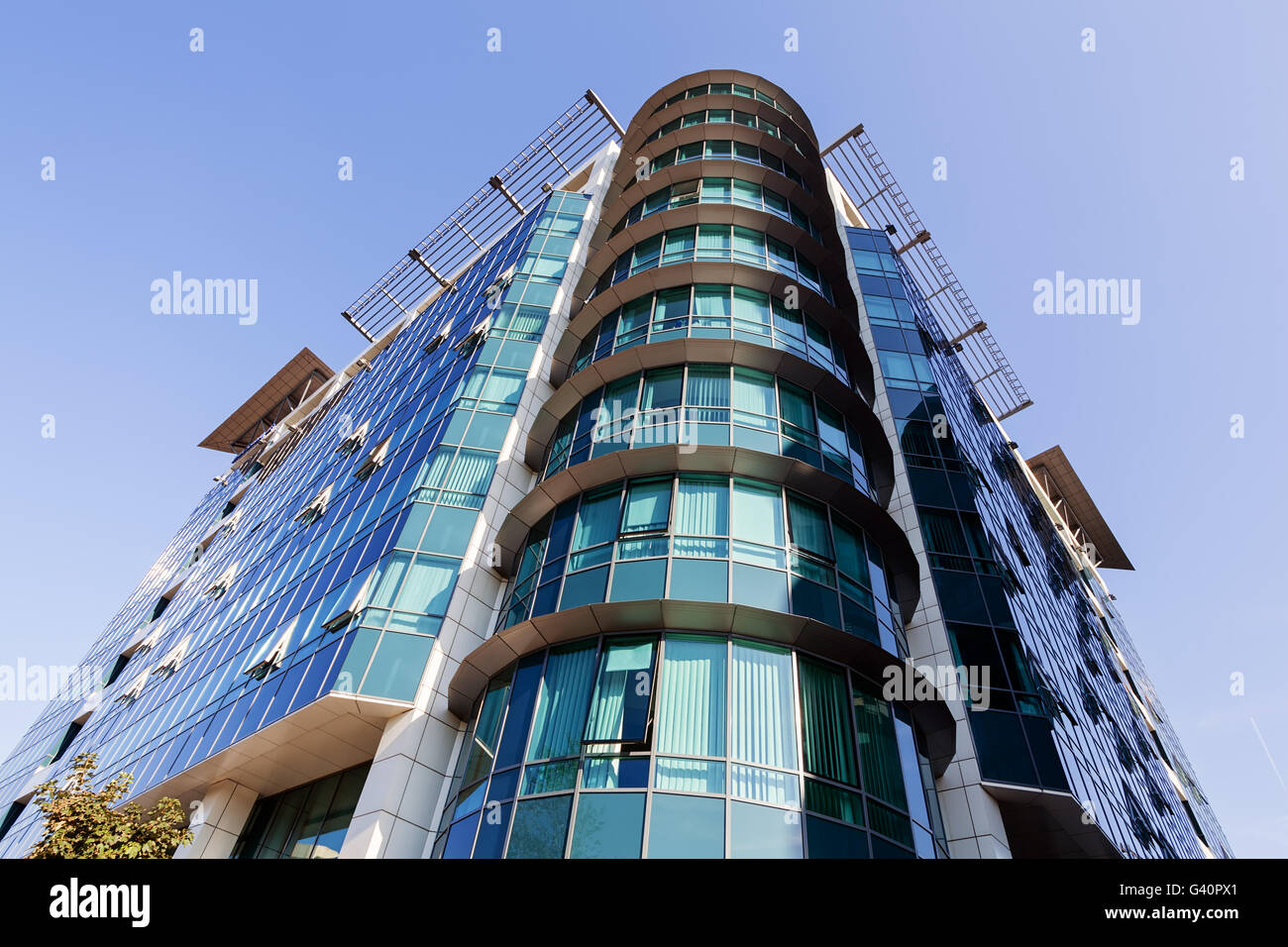 Glass reflective office building against blue sky on a sunny day Stock Photo