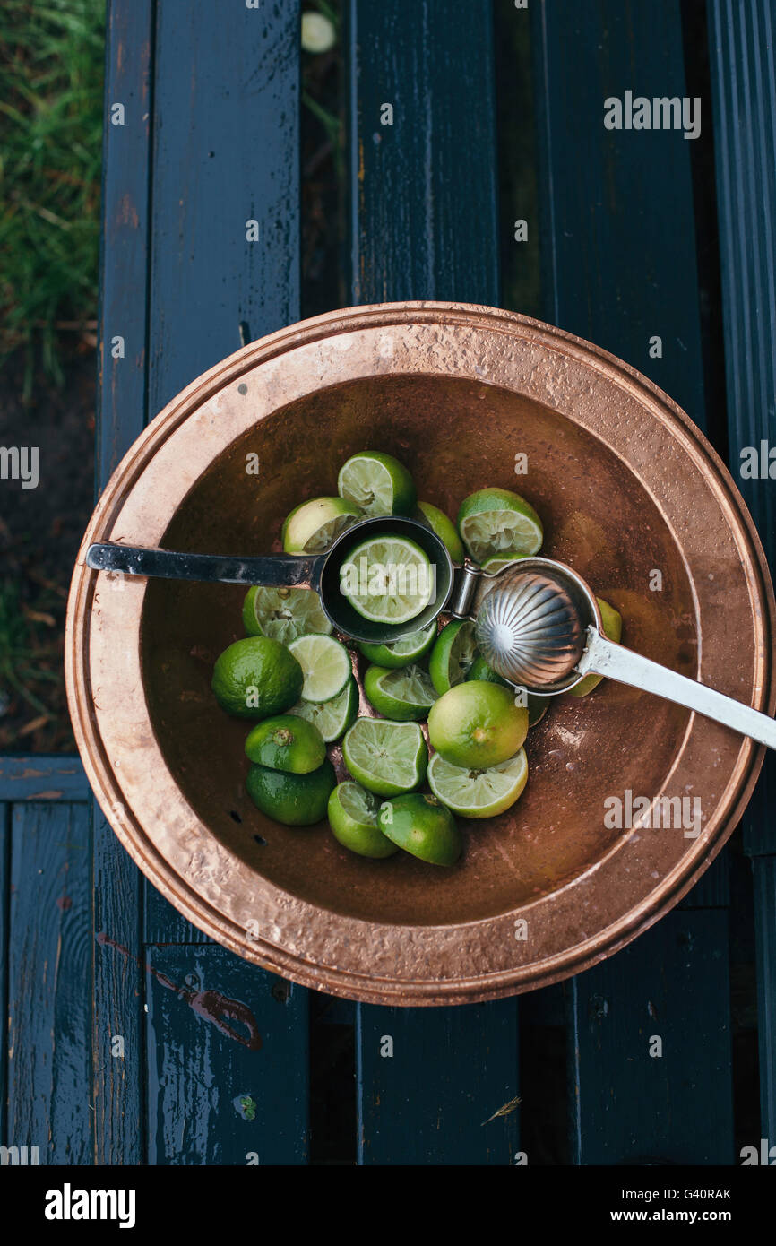 Fresh green lime in a bowl, squeezed for cocktails Stock Photo