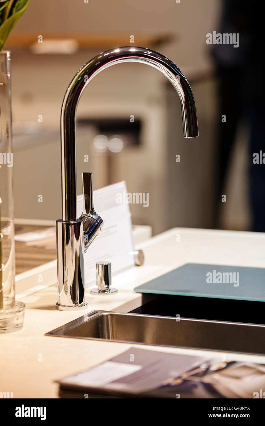 modern design of chrome faucet for sink; note shallow depth of field ...
