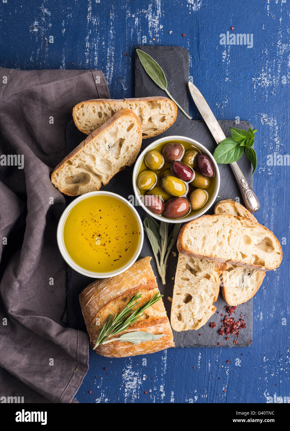 Mediterranean snacks set. Olives, oil, herbs and sliced ciabatta bread