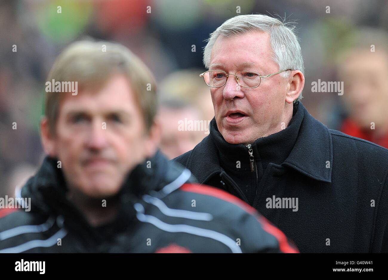 Liverpool manager Kenny Dalglish (left) and Manchester United manager Alex Ferguson (right) make their way towards pitchside before the match Stock Photo