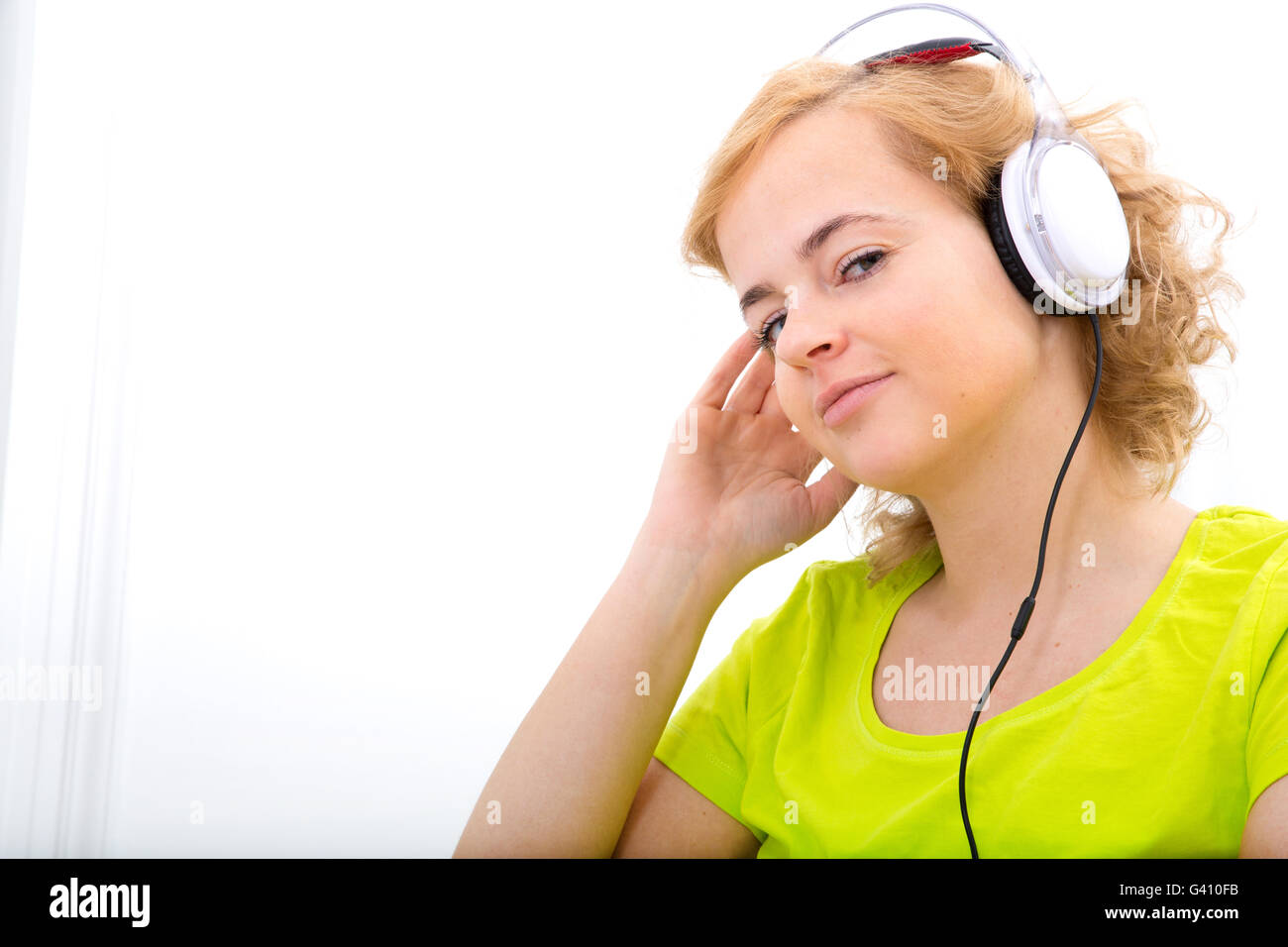 A young plus size woman listening to Audio in front of a laptop computer. Stock Photo