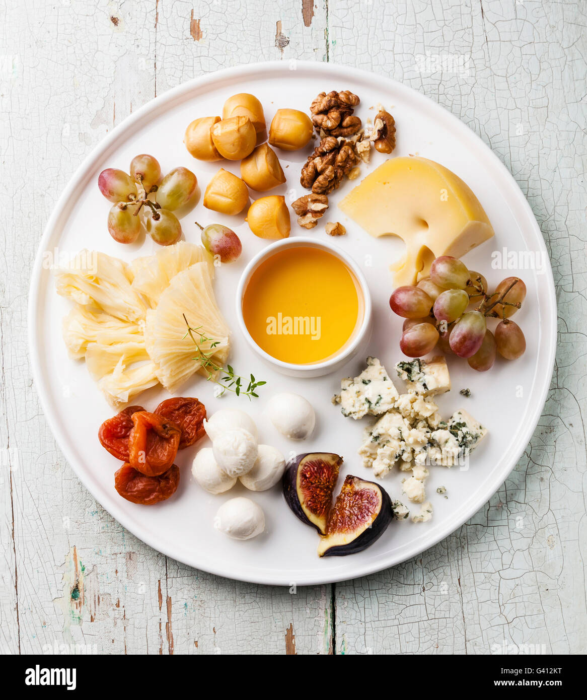 https://c8.alamy.com/comp/G412KT/cheese-plate-snacks-assortment-with-honey-on-white-plate-G412KT.jpg