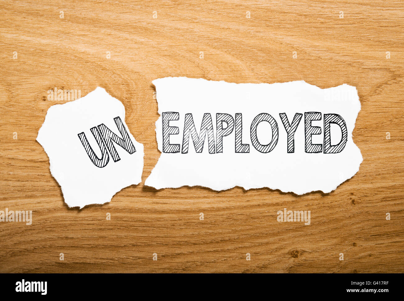 unemployed or employed: two pieces torn paper with opposite messages Stock Photo