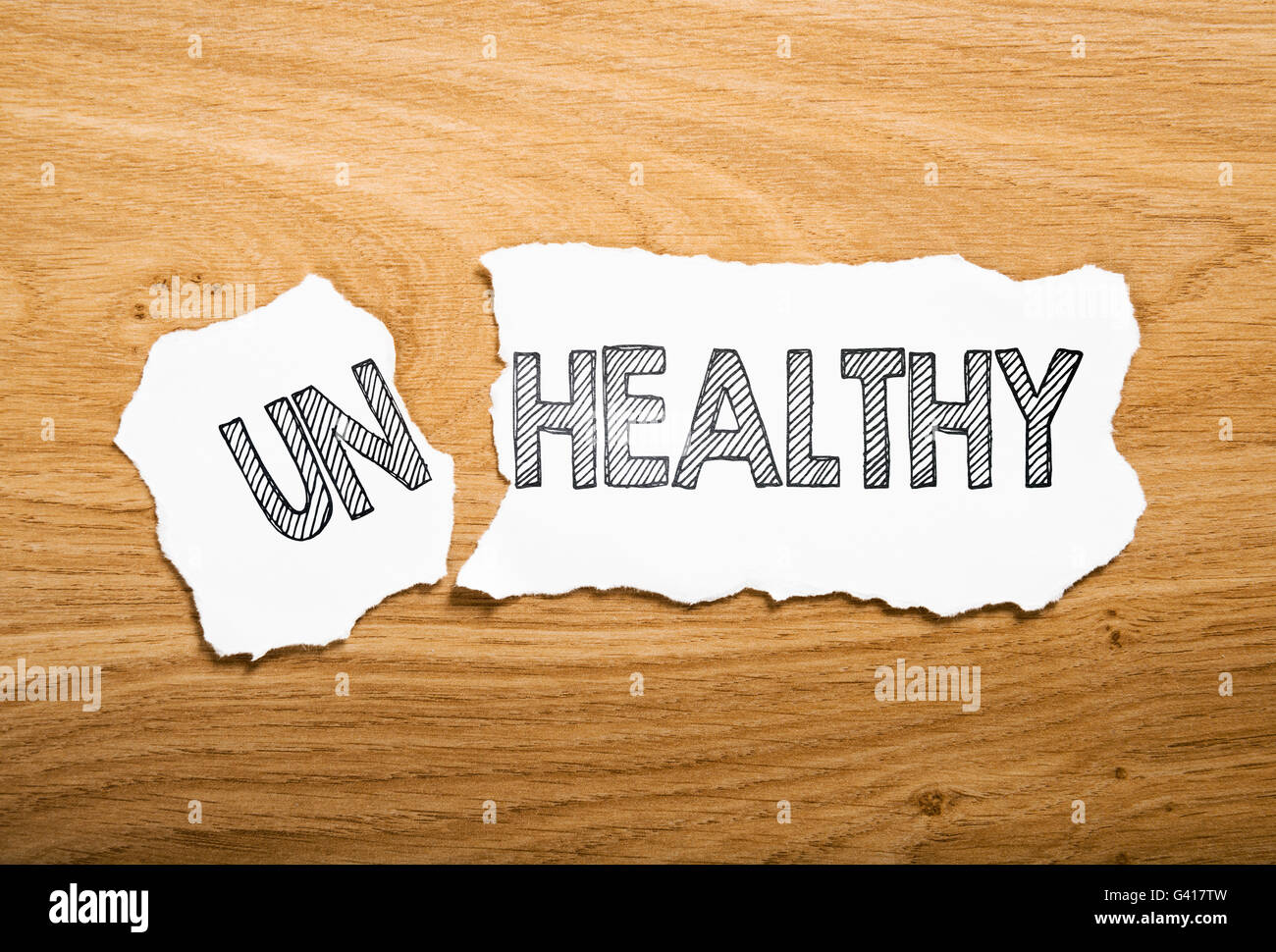 healthy or unhealthy: two pieces torn paper with opposite messages Stock Photo