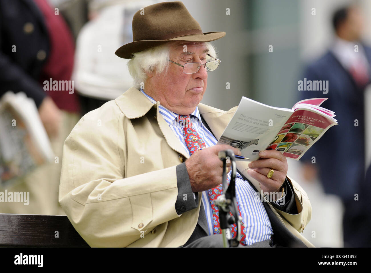 Horse Racing - The Investec Derby Festival - Ladies Day - Epsom Racecourse. A racegoer reads a programme during during The Investec Ladies Day Stock Photo