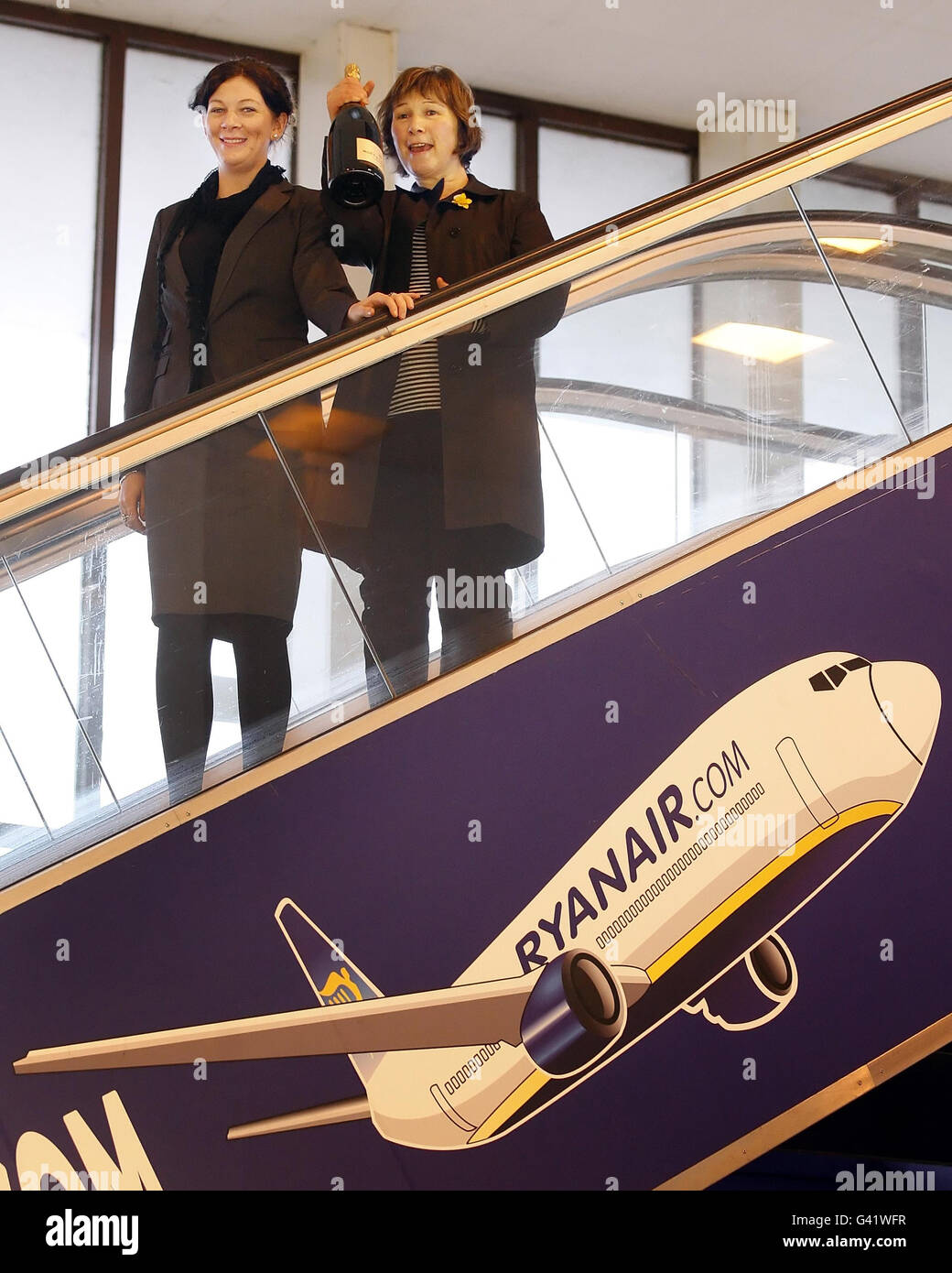 Patricia McPhillimy celebrates becoming the 20 millionth Ryanair passenger to pass through Prestwick Airport, Scotland, since the airline started operations their in 1994 with Ryanair Sales and Marketing Executive Maria Macken (left). Stock Photo