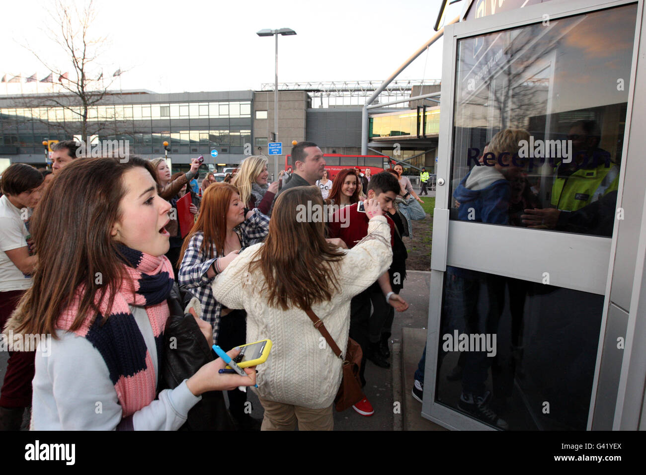 One Direction at Heathrow. Fans surround X Factor boy band stars One Direction at Heathrow Airport in London. Stock Photo
