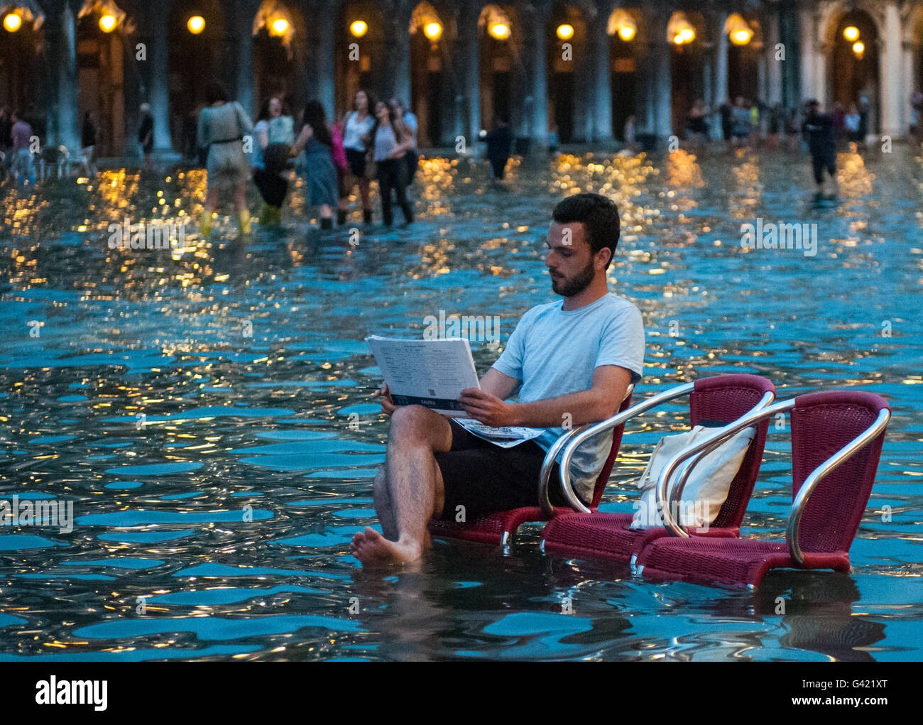 Venice, Italy. 15th June, 2016. A man draws during the high water on June 15, 2016 in Venice, Italy. The high water in this period is exceptional, and it is a surprise for citizen and tourists.  Credit:  Simone Padovani /Awakening/Alamy Live News Stock Photo