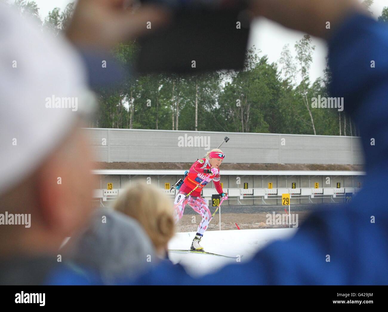 Imatra, Finland. 17th June, 2016. A spectator takes photos for a skier during a biathlon event in Imatra, Finland, on June 17, 2016. The some 500 meters long skiing track was made of last winter's natural snow. Eight skiers from Finland, Russia and Italy took part in the competition. © Li Jizhi/Xinhua/Alamy Live News Stock Photo