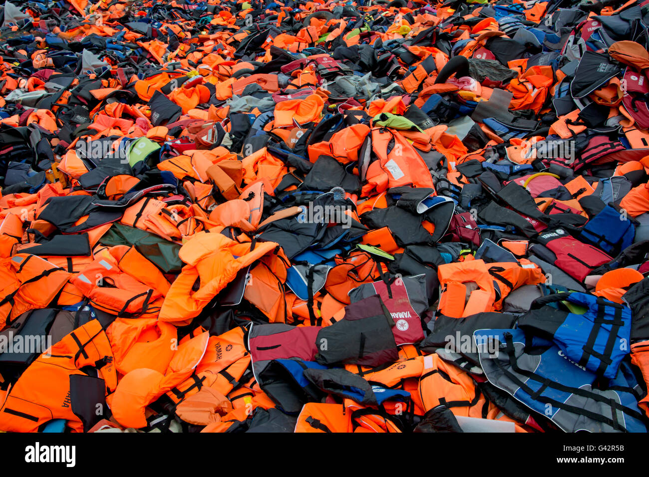 LESVOS, GREECE February 21, 2016: Lifejackets, rubber rings an pieces of the rubber dinghies left by refugees are making a mount Stock Photo