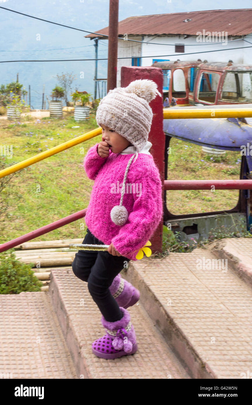 Cute little Darjeeling girl child in winter clothing, walking downstairs. Stock Photo