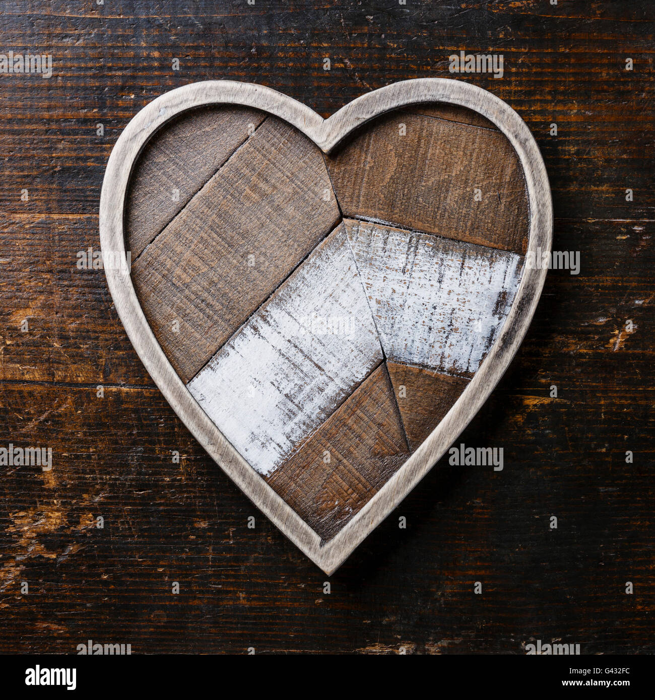 Heart shape wooden tray on dark wooden background Stock Photo