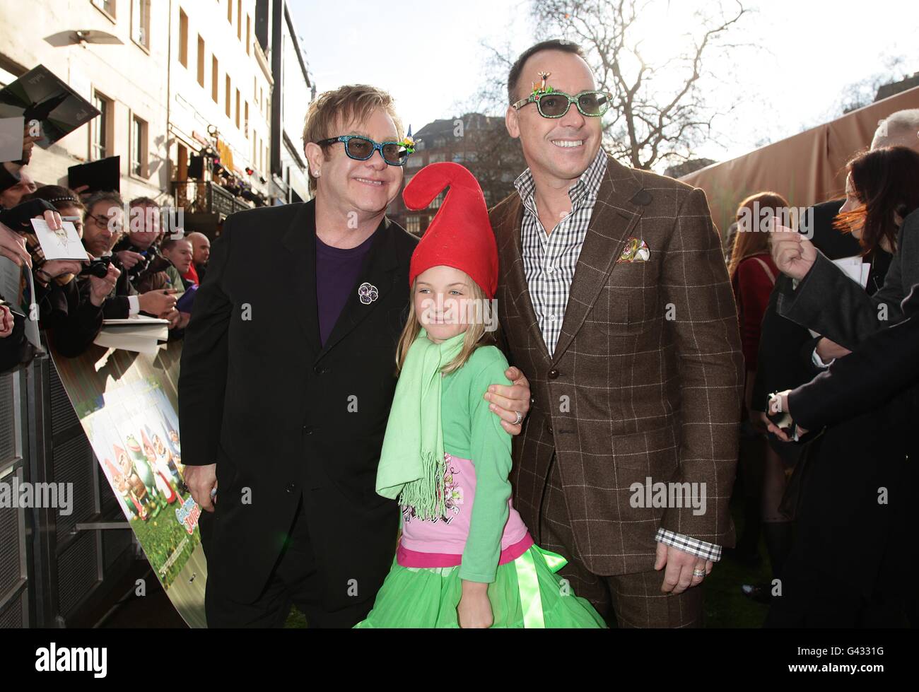 Sir Elton John and David Furnish with David's goddaughter Esme, arriving for the premiere of