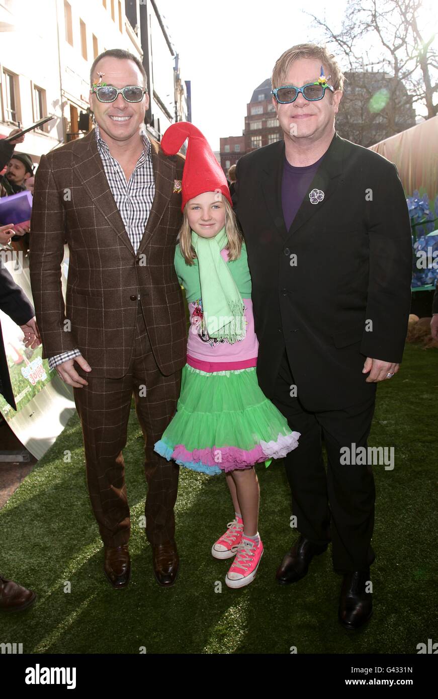 Sir Elton John and David Furnish with David's goddaughter Esme, arriving for the premiere of