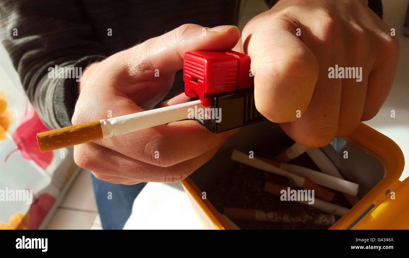 Rolling machine and cigarettes Stock Photo