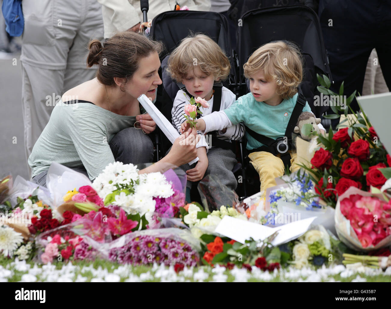 Ruth Barry and her two sons laying flowers in Parliament Square, London, after Labour MP Jo Cox was shot and stabbed to death in the street outside her constituency advice surgery in Birstall, West Yorkshire. Stock Photo