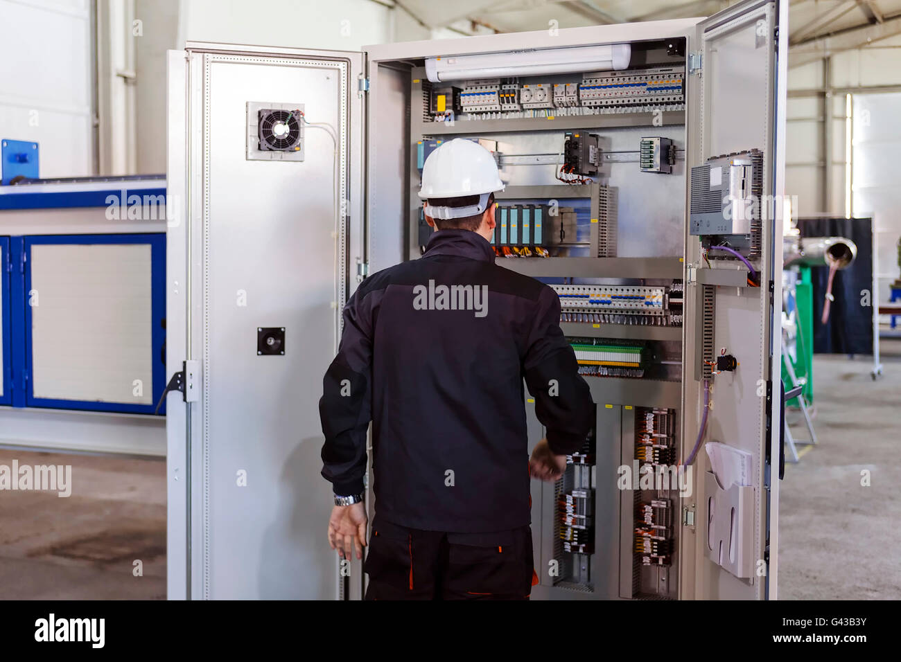 Man worker checking advanced industrial control panel; note shallow ...