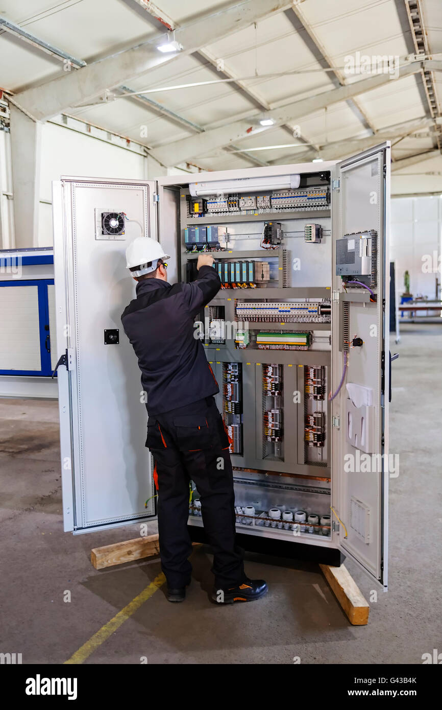 Man worker checking advanced industrial control panel in the production ...