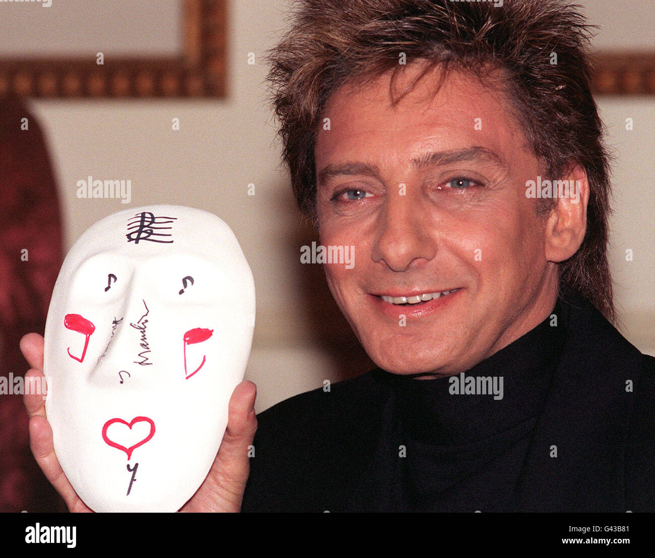 Singer Barry Manilow in London with the clay mask he has painted for The Prince's Trust, of which he has just become The Trust's American-based Ambassador. The Prince of Wales and 1000 artists and celebrities have decorated the masks for an exhibition and auction, which aims to raise in excess of 1 million for the charity. Stock Photo