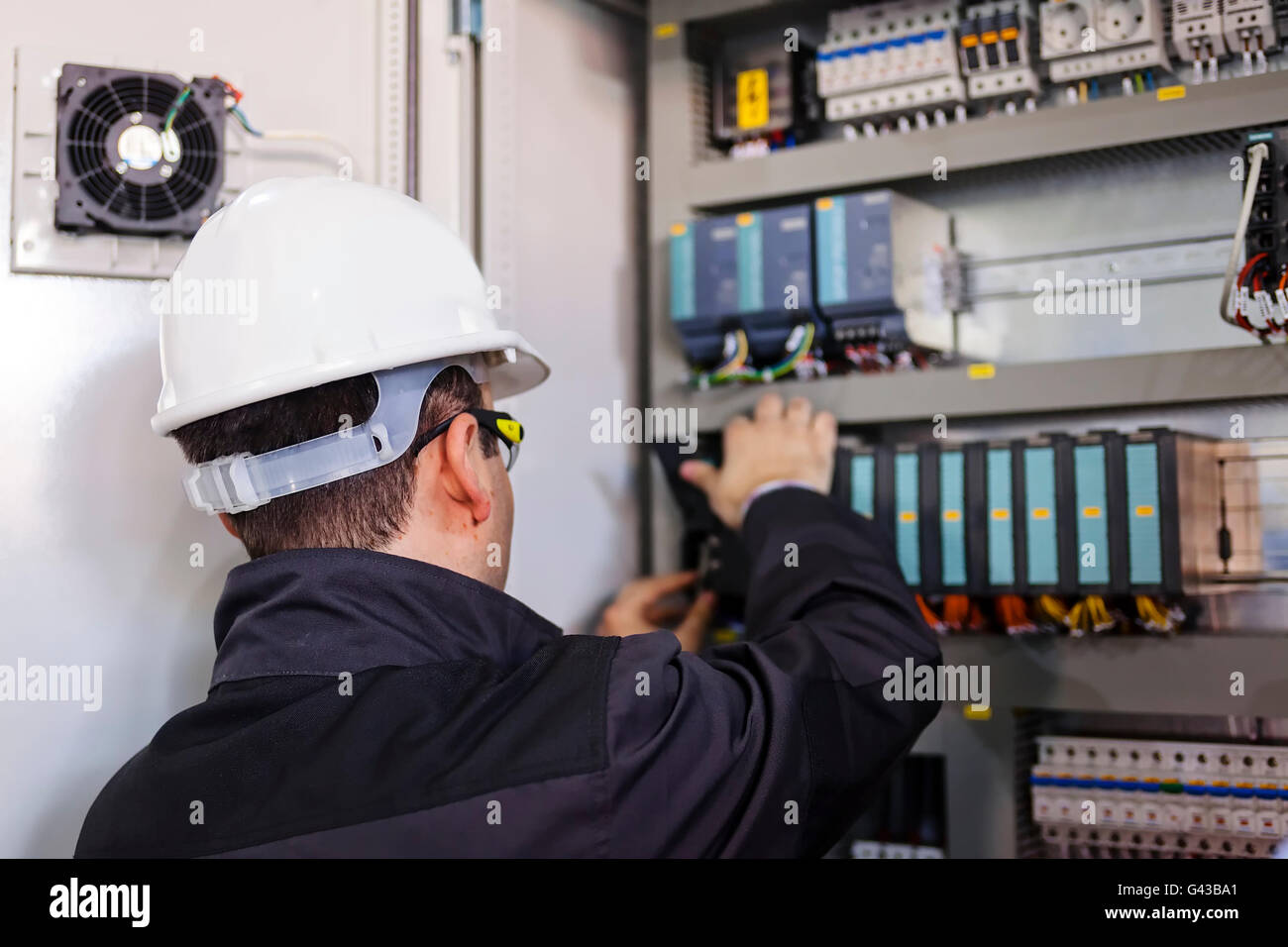 Closeup man worker checking advanced industrial control panel; note ...