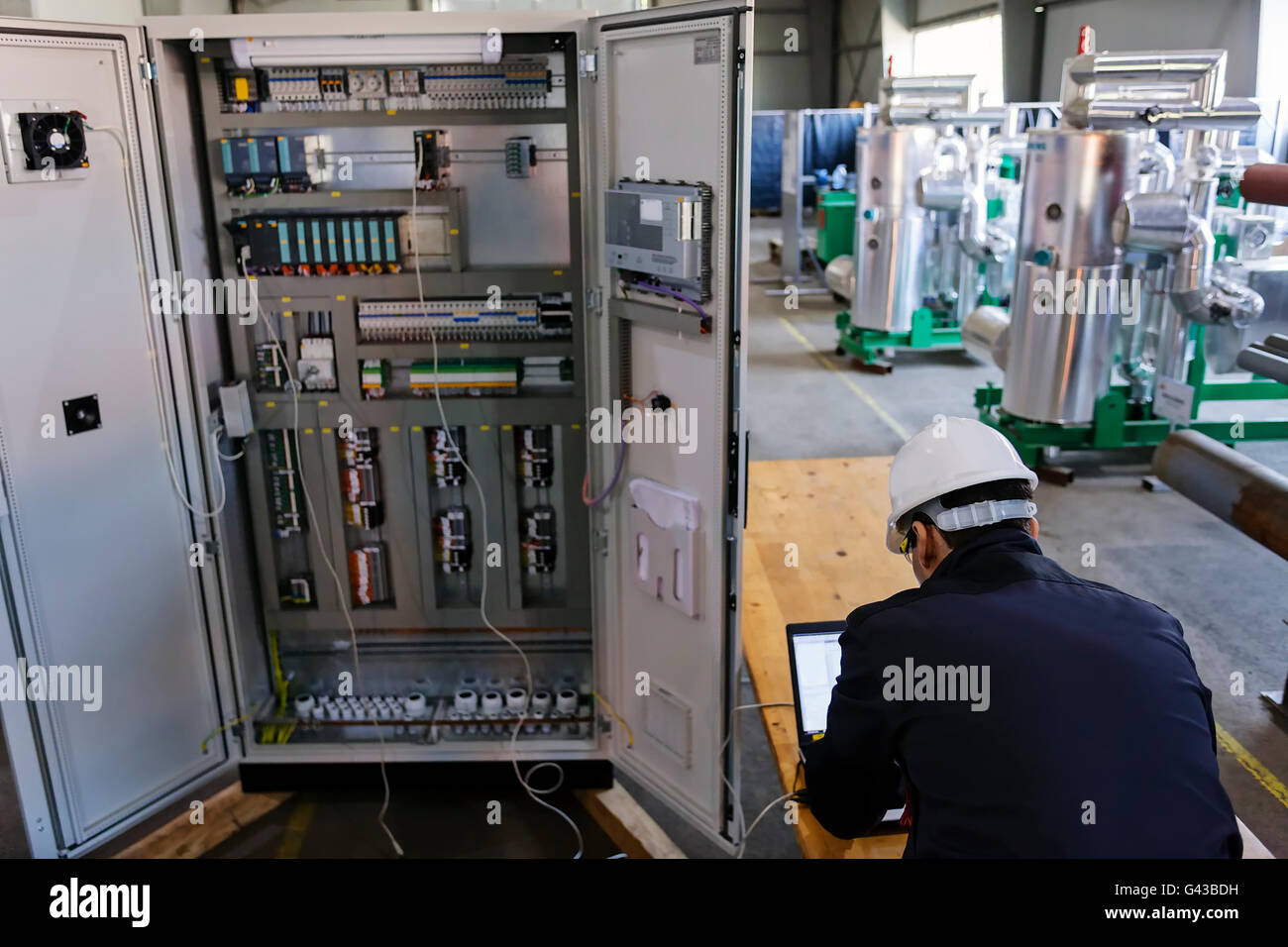 Man worker checking advanced industrial control panel in the production ...