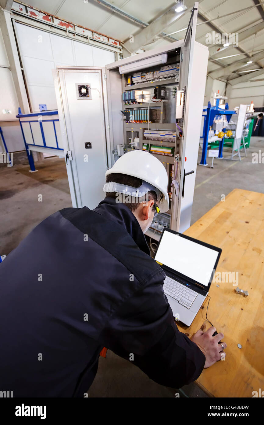 Closeup man worker checking advanced industrial control panel; note ...