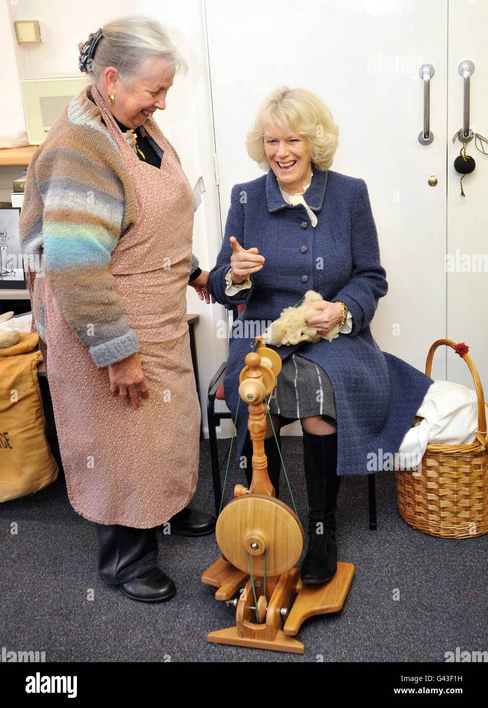 The Duchess of Cornwall is shown how to use a spinning wheel by former