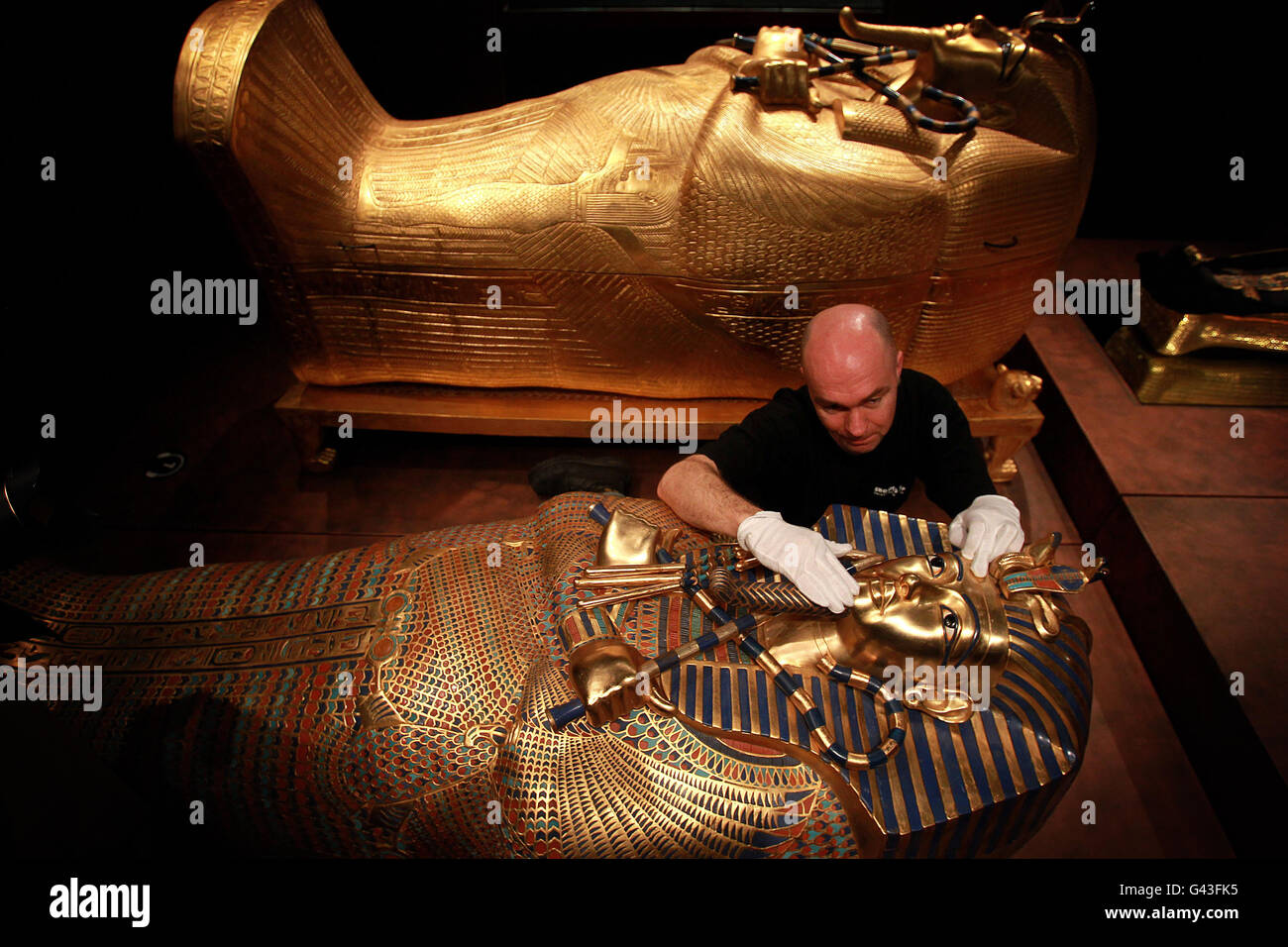 A curator examines one of the replica sarcophagus at the Tutankhamun: His Tomb and Treasures show at the Royal Dublin Society. The show recreates three burial chambers and opens on the 17th February. Stock Photo