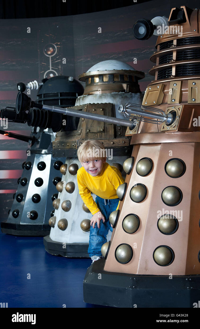 Six year old MacLaine Marshall encounters four generations of the Daleks, (from left) the1984 Dalek from Resurrection of the Daleks, the 1988 Special Weapons Dalek, the 2005 lone Dalek encountered by ninth Doctor and the new Dalek paradigm from 2010, during a sneak preview of The Doctor Who Experience - a fully interactive themed adventure and exhibition which opens at London's Olympia Two venue on Sunday 20th February. Stock Photo