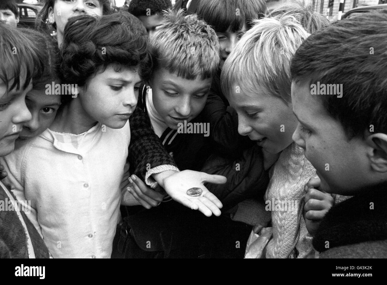 Children in Trafalgar Square, London looking at the new decimal 50 pence coin, the world's first seven sided coin. Stock Photo