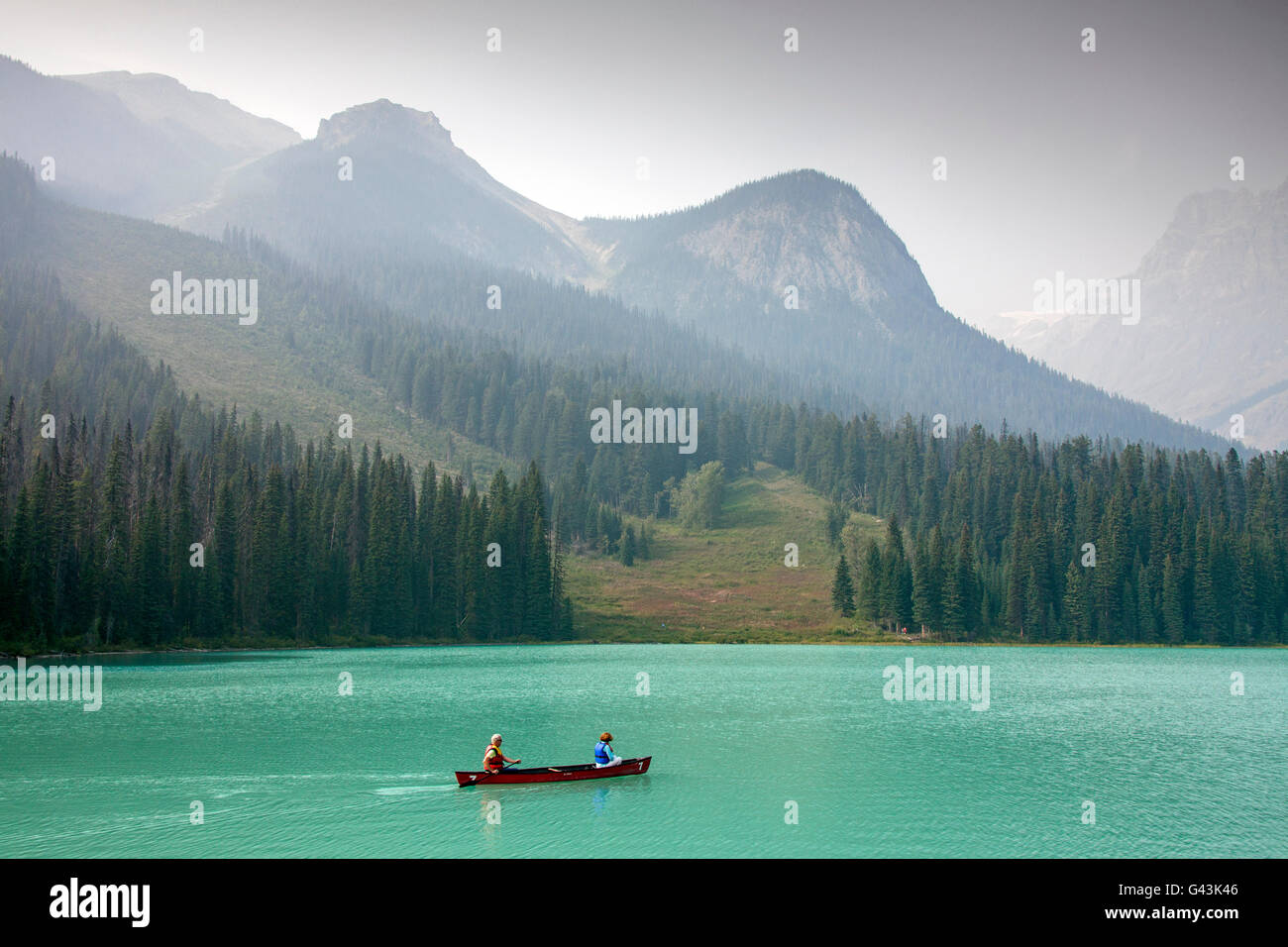 Tourists in red canoe on Emerald Lake, Yoho National Park, British