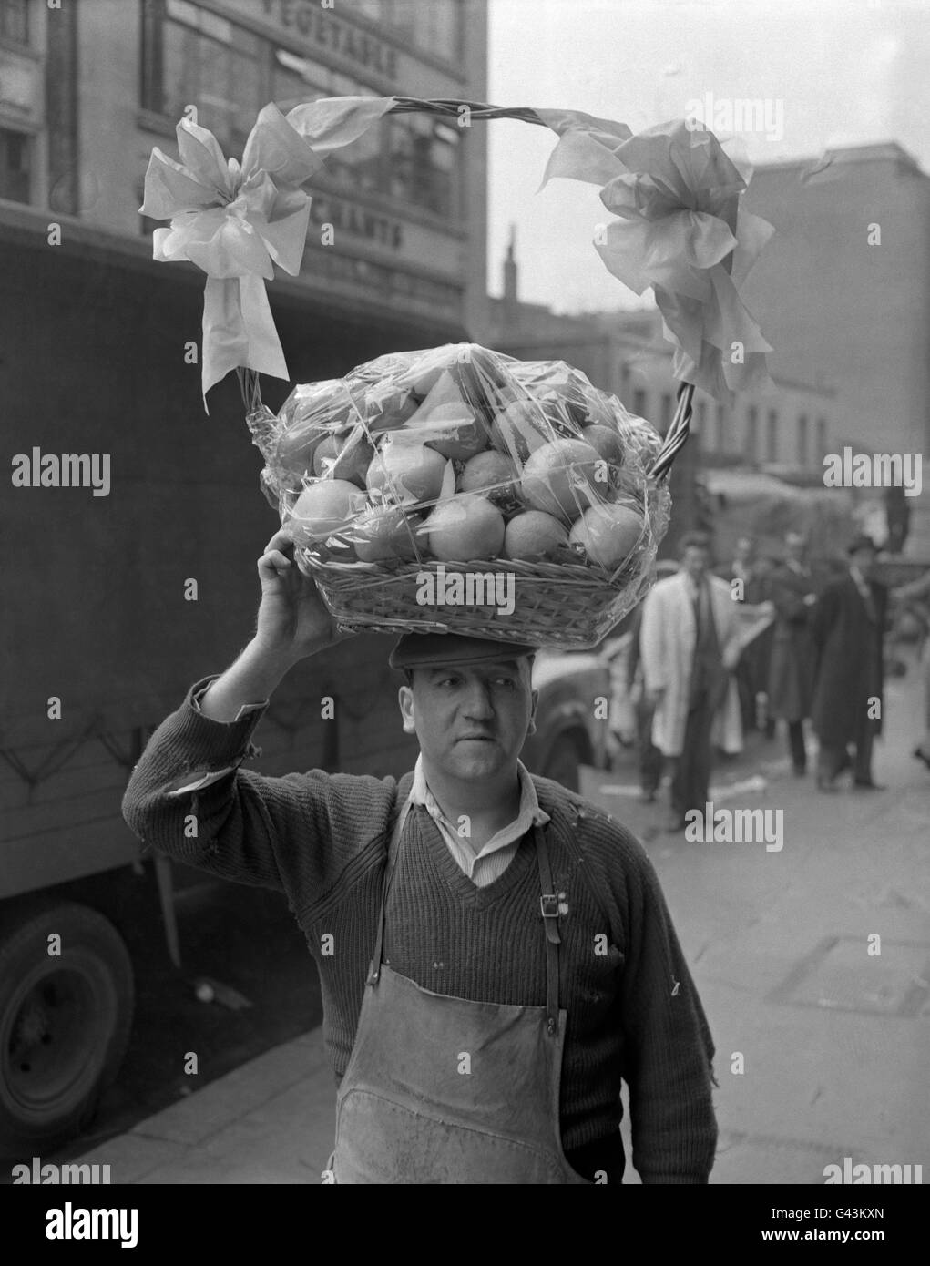 A basket of oranges and lemons, a wedding gift from Israeli growers to Princess Margaret, is carried by porter Harry Broughton from Covent Garden Market for delivery to the Royal Yacht Britannia. Stock Photo