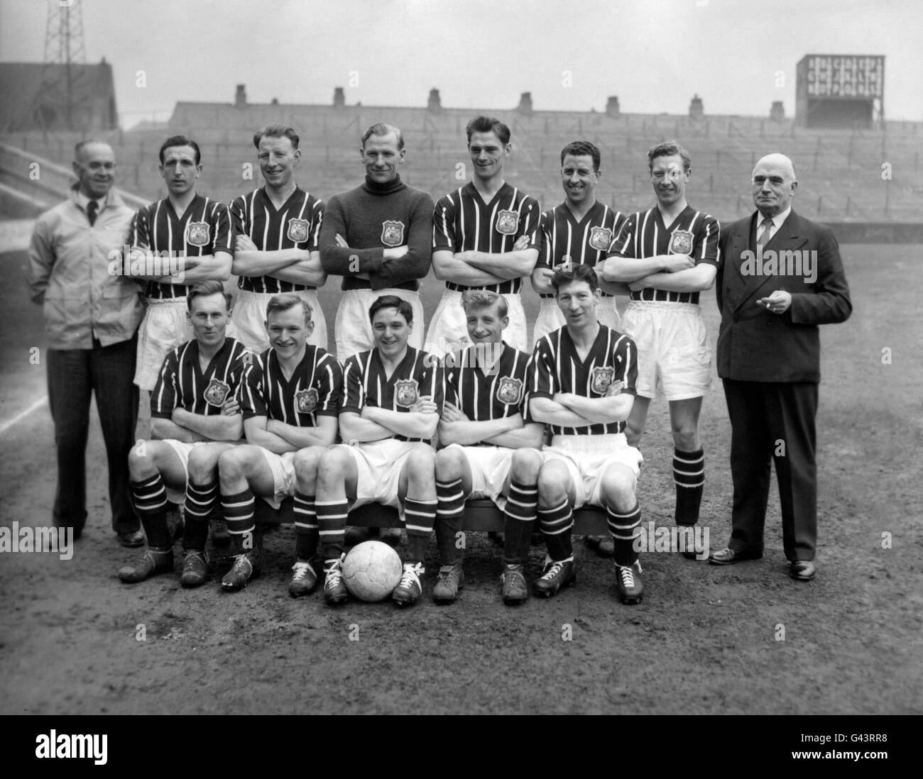 Pictured at Maine Road, Manchester, in the new striped jerseys they will wear at Wembley are the probable Manchester City team for the FA Cup final against Birmingham City. Srtanding, left to right: Laurie Barnett (trainer); Kenneth Barnes; David Ewing; Bert Trautmann; William Leivers; Roy Paul; Roy Little; and Walter Smith (Chairman). Seated, left to right: William Spurdle; Joseph Hayes; Robert Johnstone; Jack Dyson and Royston Clarke. Stock Photo