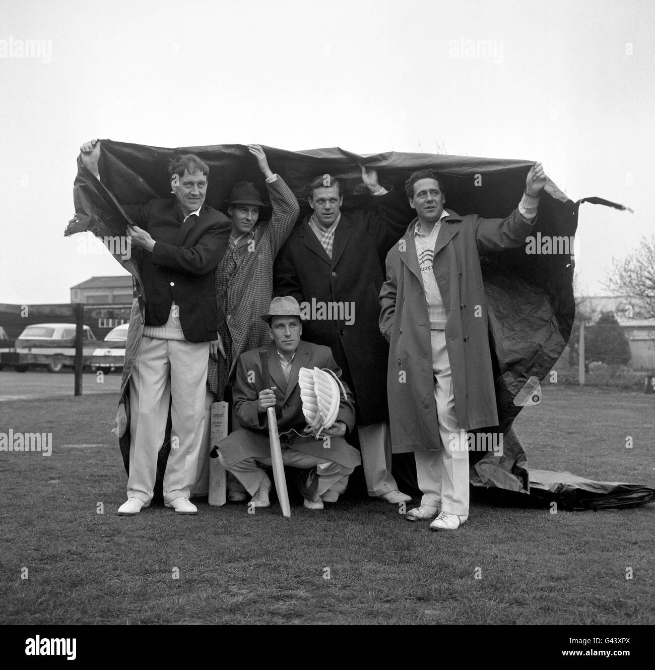 Essex County Cricket Club players taking cover at the Old Blue Rugby Football Club, Fairlop, Essex. Left to right; Bill Greensmith, Barry Knight, Ken Preston, Trevor Bailey, and Brian Taylor (crouching) Stock Photo