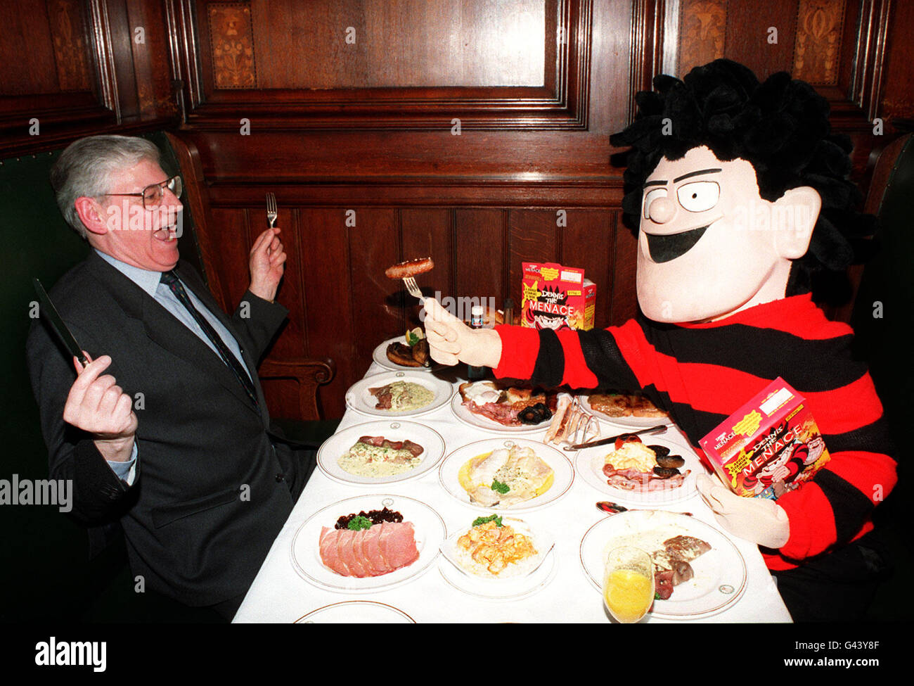 Anti-establishment hero Dennis The Menace offers Simpson's in the Strand customer Jim Gates an offering from his own brand new cereal launched today (Fri) called Dennis The Menace Strawberry Jammees. The Jammees are packed with six added vitamins and iron while the distinctive packs has a comic strip on the back containing a free stand-up figure of Dennis or one of his pals. Stock Photo