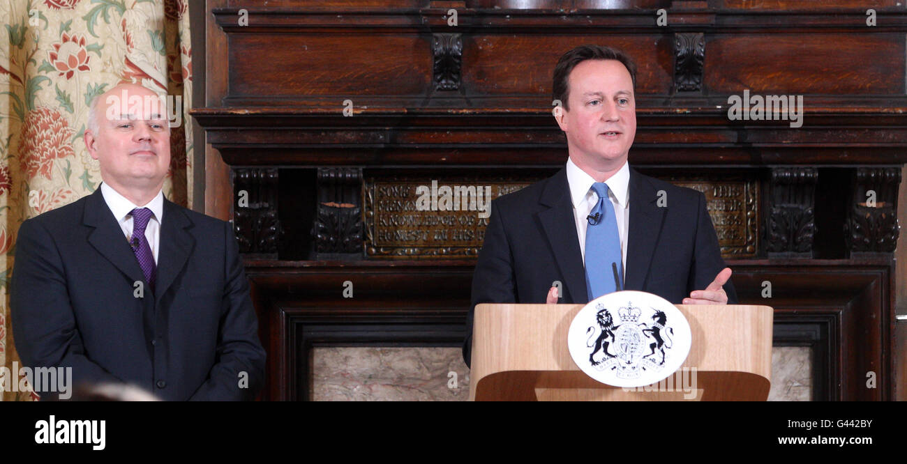 Prime Minister David Cameron (right) makes a speech on welfare at Toynbee Hall in East London, as Work and Pensions Secretary Iain Duncan Smith looks on. Stock Photo