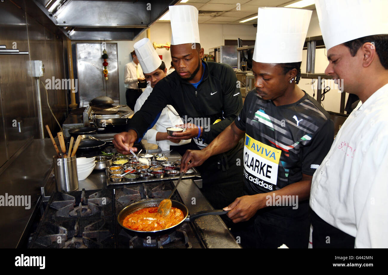 Jamaican athlete Lerone Clarke and USA's David Payne cook a 'balti' curry during a photocall at Shimla Pinks, Birmingham. Stock Photo