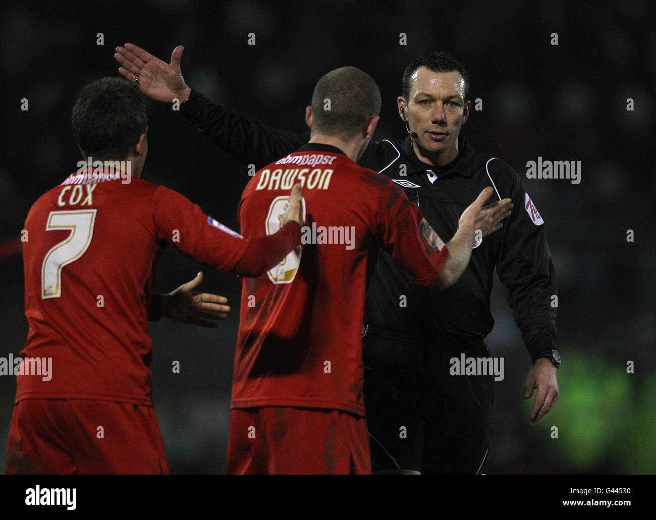 Leyton Orient's Dean Cox (left) and Stephen Dawson appeal for a decision from referee Kevin Friend (right) Stock Photo