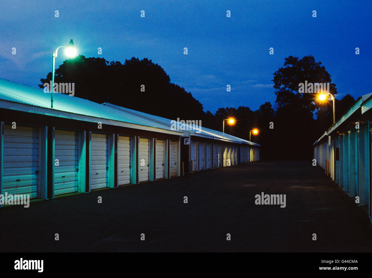 Night view of garage like rental storage units lined up in a row Stock