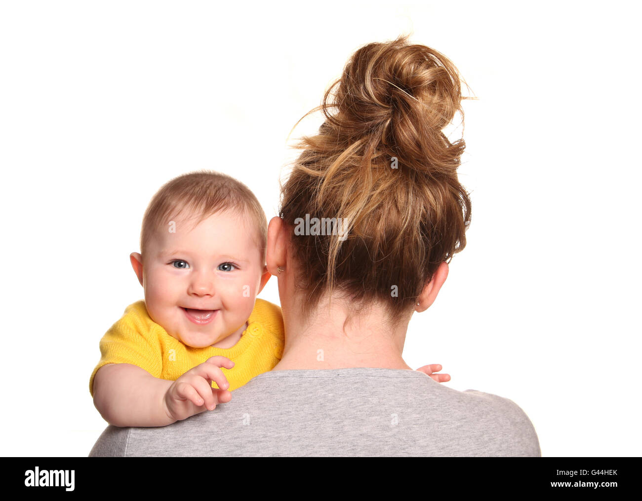 Mother carrying baby girl looking over shoulder cutout Stock Photo