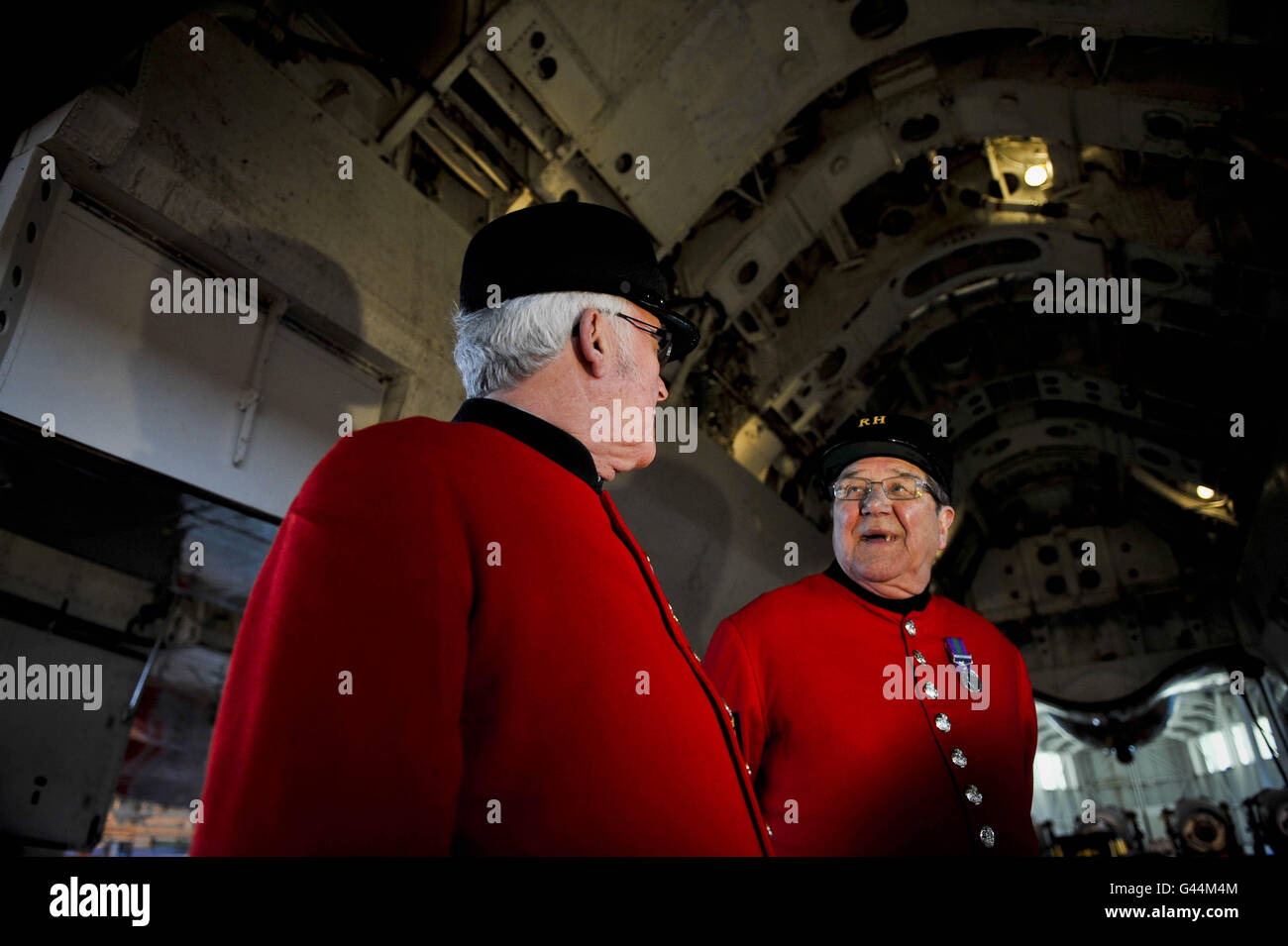 Chelsea pensioners chat beneath the bomb bay on the world's only flying Vulcan bomber during their visit and tour around the famous aircraft, which is being prepared at RAF Lyneham, Wiltshire, for the forthcoming run of air shows across the UK in 2011. Stock Photo
