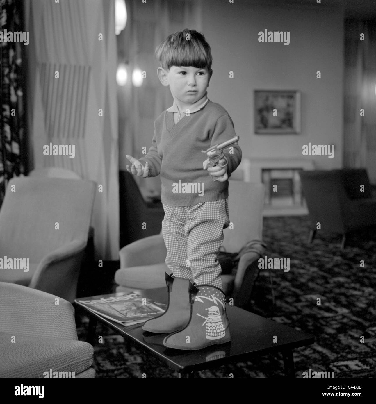 Two-year-old David Furman, of Hull, whose father owns a shoe shop, wearing the latest thing in slippers - decorated with a Dalek motif, from the BBC television programme 'Dr Who'. Stock Photo