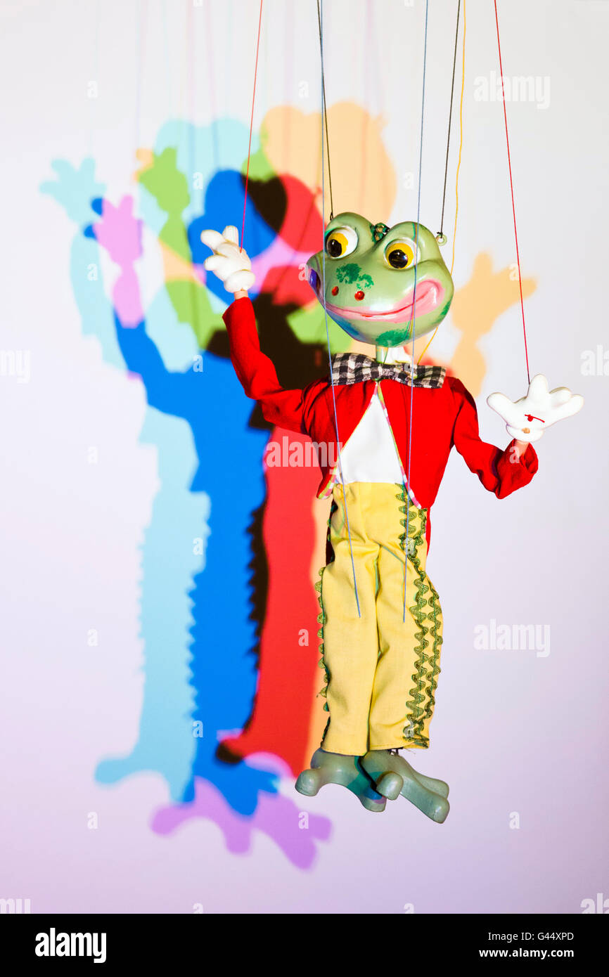 An old Pelham frog puppet lit to cast coloured shadows Stock Photo