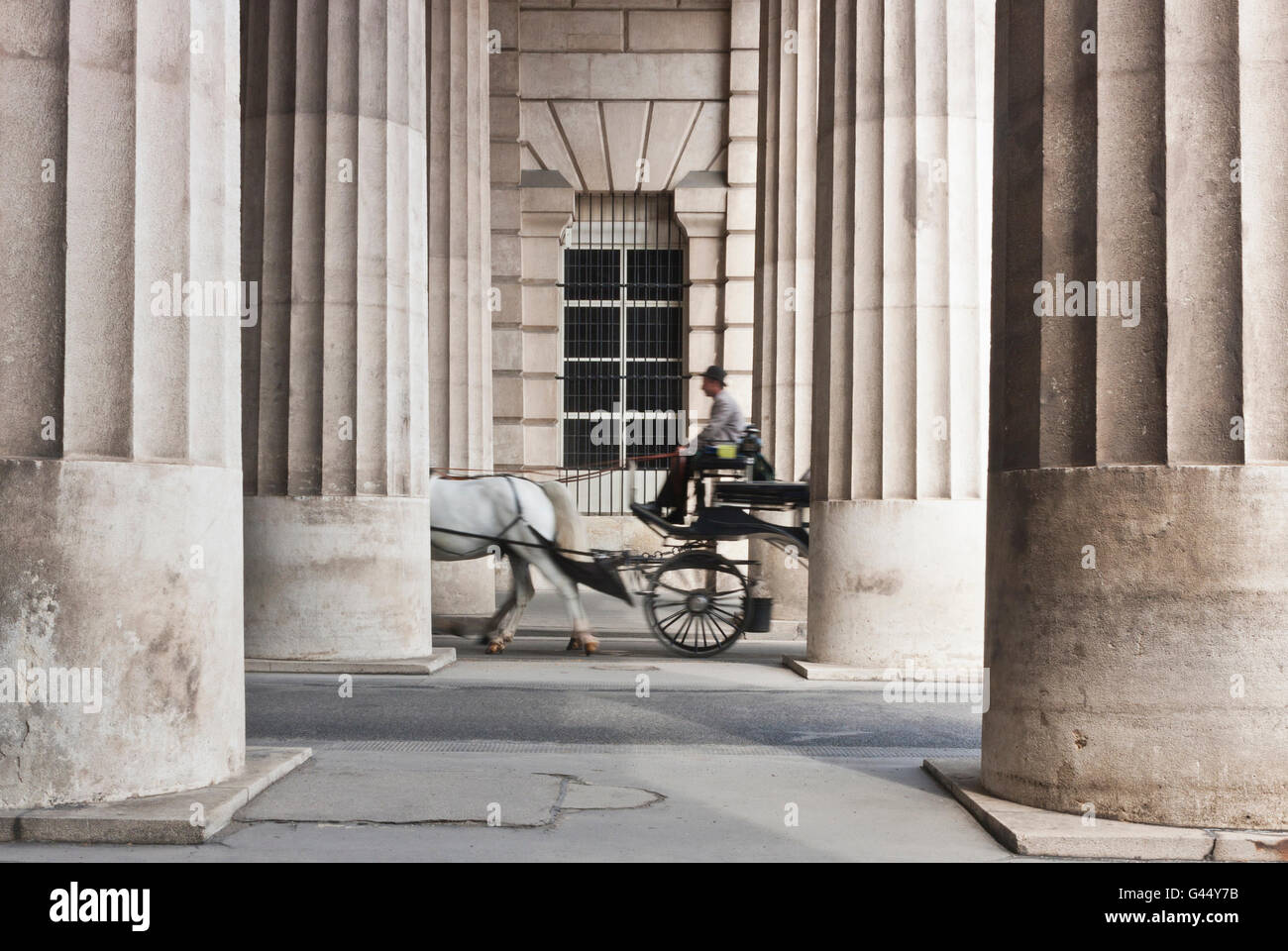 Horse-drawn carriage passing through the collonnade in Vienna, Austria Stock Photo