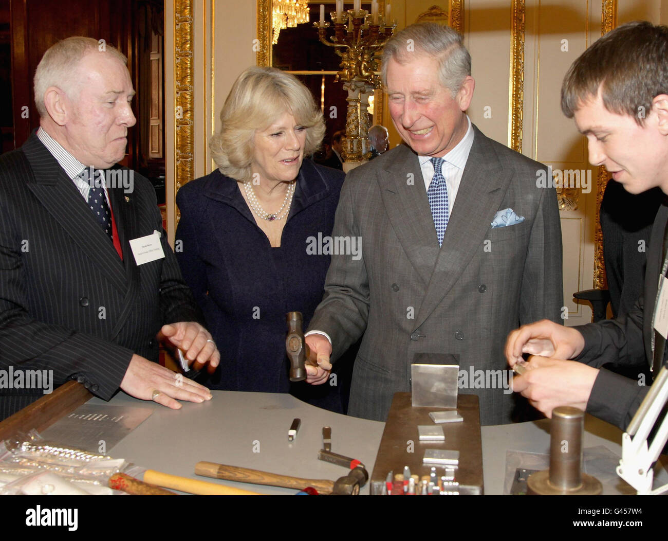 The Prince of Wales hammers a hallmark into a piece of silver as he and the Duchess of Cornwall visit to Goldsmiths Hall, London. Stock Photo