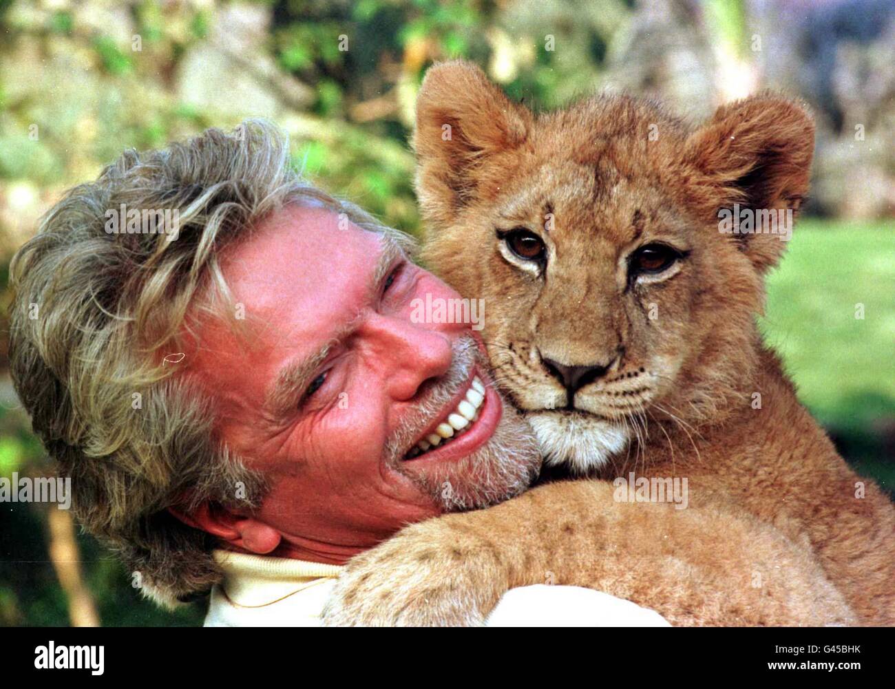 Virgin boss Richard Branson cuddles a young lion cub at Sun City in South Africa after ariving on his inaugural flight to Johannesburg, South Africa, last Thursday. Photo by Adam Butler/PA. Stock Photo