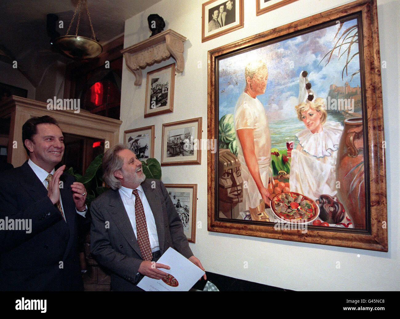 A new portrait by Canadian artist Andre Durand and commisioned by Mario Molino ( left) was officially unveiled tonight (Tuesday) by film producer Sir David Puttnam (right) in Molino's Da Mario restaurant in London. The Princess of Wales is portrayed as a pizza-loving clown. See PA Story ARTS Diana. PA Photos. Stock Photo